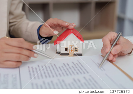 Real Estate Agreement. Agent and client discussing contract details. 137726573