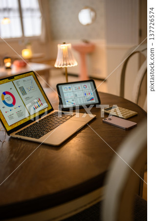 Laptop and tablet on a round table 137726574