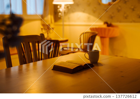 A book opened in a warm-colored room. A book opened in a warm-colored room. 137726612
