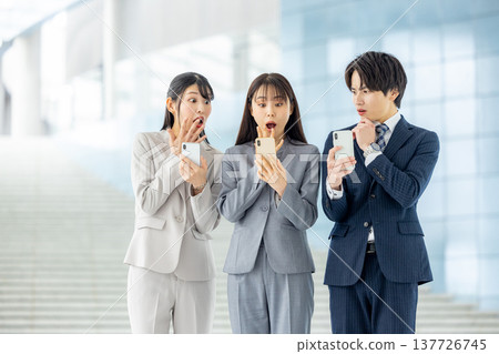 Men and women surprised at their smartphones 137726745