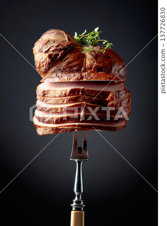 Sliced smoked gammon with thyme branches on a fork. Sliced smoked gammon with thyme branches on a fork. 137726830