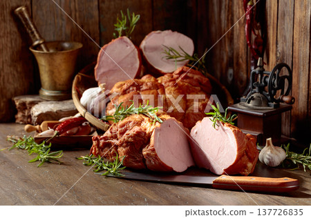 Smoked ham on an old wooden table. 137726835