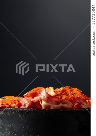 Fried bacon slices in old black pan. Fried bacon slices in old black pan. 137726844
