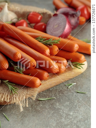 Thin smoked sausages with tomatoes, onion, garlic, and rosemary. Thin smoked sausages with tomatoes, onion, garlic, and rosemary. 137726871