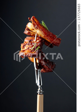 Grilled pork belly with rosemary on a fork. 137726883