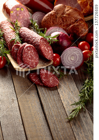 Food tray with delicious salami, ham, fresh sausages, tomato, and rosemary. Food tray with delicious salami, ham, fresh sausages, tomato, and rosemary. 137726889
