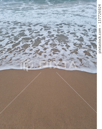 It is a beach with waves crashing in It is a beach with waves crashing in 137726924