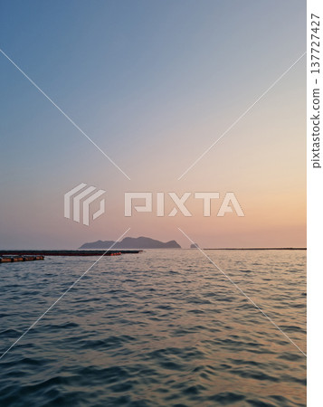 This is the sunset over the sea where the fish farm is located. This is the sunset over the sea where the fish farm is located. 137727427