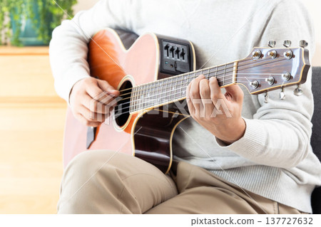 Hands of a middle-aged man playing the guitar Hands of a middle-aged man playing the guitar 137727632