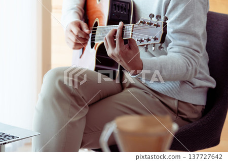 Hands of a middle-aged man playing the guitar Hands of a middle-aged man playing the guitar 137727642