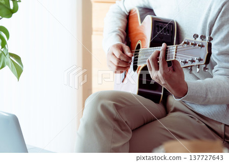 一位中年男子彈吉他的手 137727643