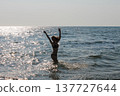 Young woman enjoying sea and sun while swimming on summer vacation 137727644