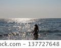 Young woman silhouette going into the sea to swim in sunny day 137727648
