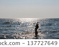 Young woman enjoying the sunshine while swimming on summer vacation on seaside 137727649