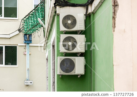 air conditioning on facade of building, air cooling in hot weather. air conditioning on facade of building, air cooling in hot weather. 137727726