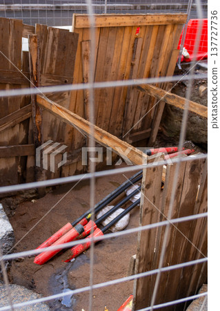 black plastic pipes in ground for drainage of sewage rainwater, lying in trench of sand. black plastic pipes in ground for drainage of sewage rainwater, lying in trench of sand. 137727736