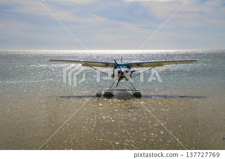 Single-Engine Seaplane on Calm Sea off Beach in Mauritius, Africa Single-Engine Seaplane on Calm Sea off Beach in Mauritius, Africa 137727769