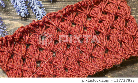 Knitting patterns with a raised pattern and yarn on a dark background Terracotta Knitting patterns with a raised pattern and yarn on a dark background Terracotta 137727952