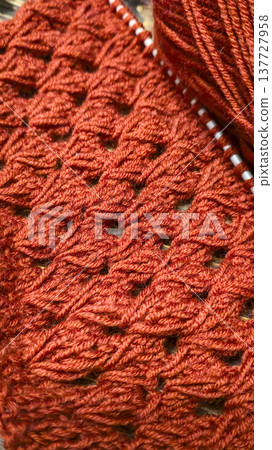 Knitting patterns with a raised pattern and yarn on a dark background Terracotta Knitting patterns with a raised pattern and yarn on a dark background Terracotta 137727958