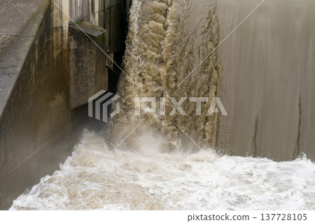 Discharge of water at the dam during flood. Powerful water flow 137728105