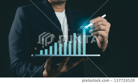 Businessman Analyzing Graph with Cost Increase on Digital Tablet in Dark Background for Financial Growth and Investment Strategies 137728520