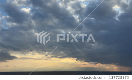 Light filtering through thick clouds, the evening sky, and the horizon. Light filtering through thick clouds, the evening sky, and the horizon. 137728573