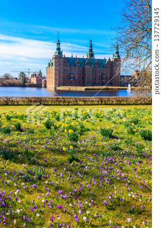 View of Frederiksborg castle in Hillerod, Denmark. Beautiful lake and garden with crocuses and daffodils on a foreground View of Frederiksborg castle in Hillerod, Denmark. Beautiful lake and garden with crocuses and daffodils on a foreground 137729145
