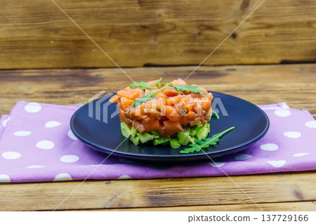 Salmon tartare with avocado and arugula on wooden table Salmon tartare with avocado and arugula on wooden table 137729166