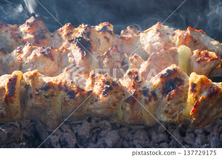 Grilled kebab cooking on metal skewer. Roasted meat cooked at barbecue.Traditional eastern dish, shish kebab. Grill on charcoal and flame, picnic, street food Grilled kebab cooking on metal skewer. Roasted meat cooked at barbecue.Traditional eastern dish, shish kebab. Grill on charcoal and flame, picnic, street food 137729175