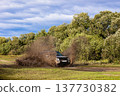 Japanese SUV moving by a puddle making a lot of dirt splashes 137730382