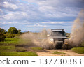 Japanese SUV moving by a puddle making a lot of water splashes 137730383