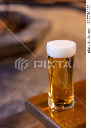 A delicious draft beer enjoyed by the fireplace in winter A delicious draft beer enjoyed by the fireplace in winter 137730951