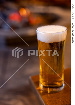 A delicious draft beer enjoyed by the fireplace in winter A delicious draft beer enjoyed by the fireplace in winter 137730955