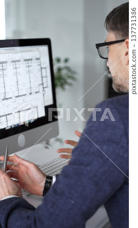 Architects and engineers discussing building blueprint plans on a computer monitor and paper drawings. Business people and architecture concept 137731386