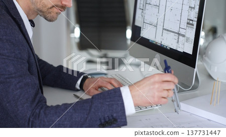 Professional architect drafting blueprints at a desk, holding a compass, focusing on structural plans and urban design. Business and architecture concept Professional architect drafting blueprints at a desk, holding a compass, focusing on structural plans and urban design. Business and architecture concept 137731447