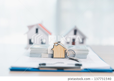 Home buying and mortgage planning concept for real estate investment and insurance, featuring a miniature house, keys, calculator, pen and contract on a bright desk in a modern office. real estate Home buying and mortgage planning concept for real estate investment and insurance, featuring a miniature house, keys, calculator, pen and contract on a bright desk in a modern office. real estate 137731540