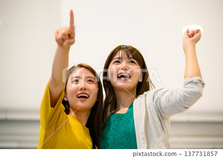 Two women pointing upwards. ■Filming assistance provided by: Kansai International Airport (KIX) Two women pointing upwards. ■Filming assistance provided by: Kansai International Airport (KIX) 137731857