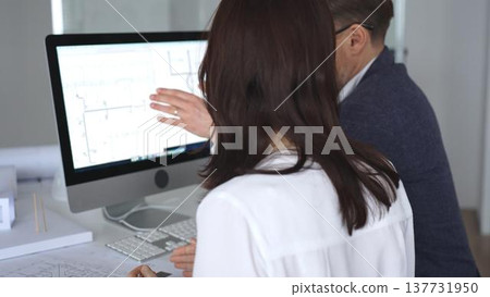 Architects collaborating on building plans using computer aided design software and architectural models. Business and architecture concept 137731950