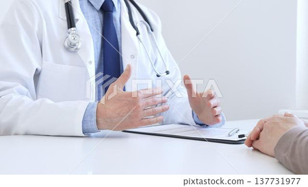 Adult doctor gesturing with hands while explaining diagnosis to patient during medical consultation in hospital office, healthcare and medical concept. Medicine concept Adult doctor gesturing with hands while explaining diagnosis to patient during medical consultation in hospital office, healthcare and medical concept. Medicine concept 137731977
