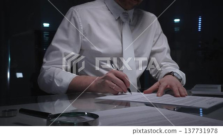 Business man signing a contract late in the office, closing a deal, or completing legal paperwork at deep night. Audit and overworking concepts Business man signing a contract late in the office, closing a deal, or completing legal paperwork at deep night. Audit and overworking concepts 137731978