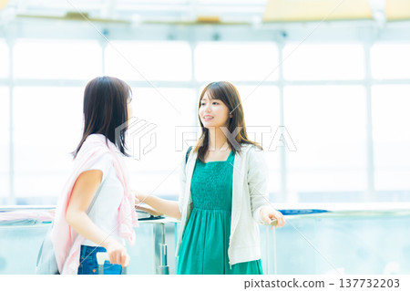 Two women having a conversation at the airport. Photo courtesy of Kansai International Airport (KIX). 137732203