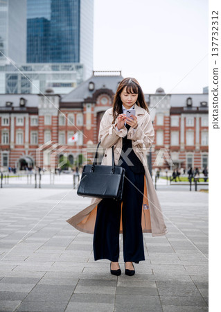 A businesswoman using a smartphone in the city A businesswoman using a smartphone in the city 137732312