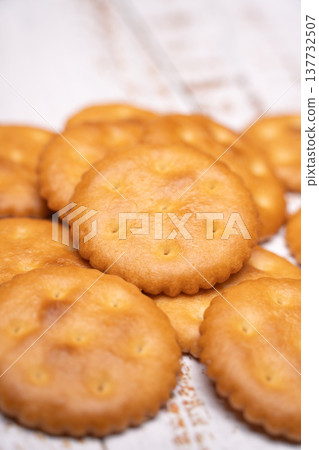 A still life photograph of a white wooden table and crackers. 137732507