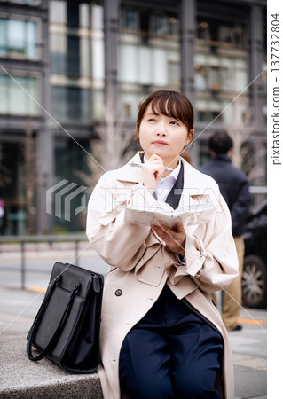 Young business woman looking at her notebook Young business woman looking at her notebook 137732804