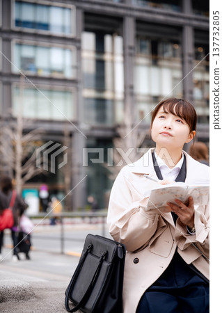 Young business woman looking at her notebook Young business woman looking at her notebook 137732805