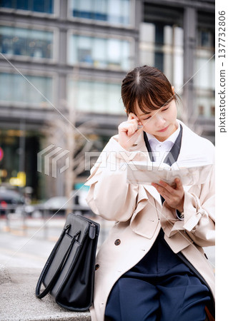 Young business woman looking at her notebook Young business woman looking at her notebook 137732806