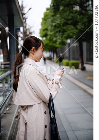 一位年輕的女商人正在辦公區打電話。 137732866