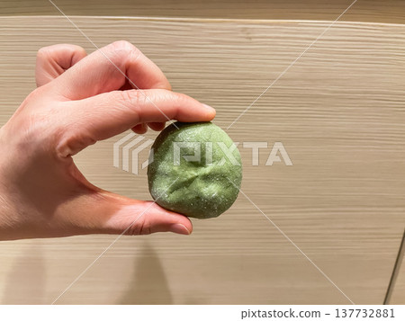 Yomogi mochi is a type of Japanese confectionery. It is made by wrapping red bean paste in mochi (rice cake) that has been kneaded with mugwort. Yomogi mochi is a type of Japanese confectionery. It is made by wrapping red bean paste in mochi (rice cake) that has been kneaded with mugwort. 137732881