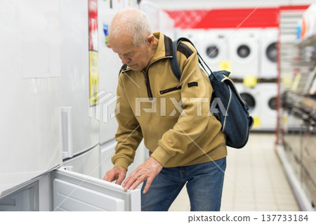 senor man pensioner buying fridge in showroom of electrical appliance store senor man pensioner buying fridge in showroom of electrical appliance store 137733184