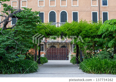 a green arch made of trees in front of the entrance to the house in Venice a green arch made of trees in front of the entrance to the house in Venice 137734162